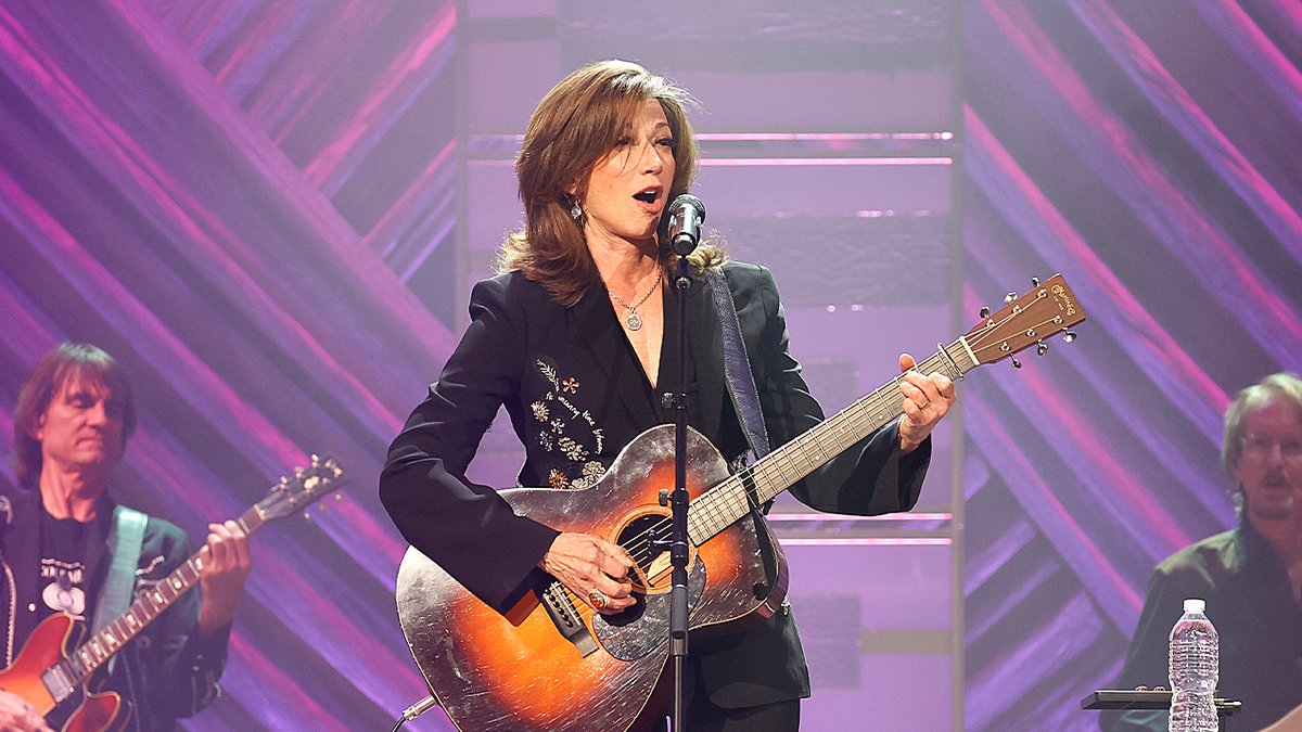 Amy Grant on stage with purple background.