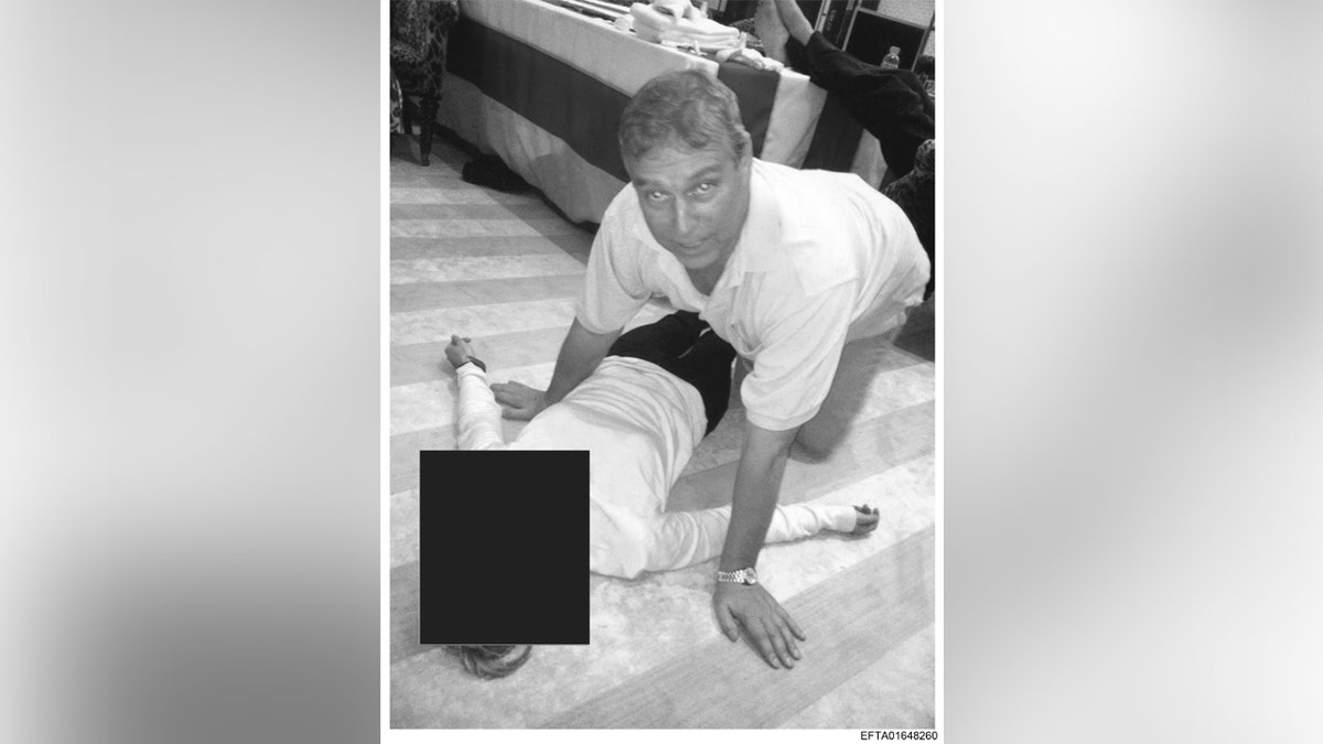 Una foto en blanco y negro de Andrew arrodillado junto a una mujer mientras mira hacia la cámara.