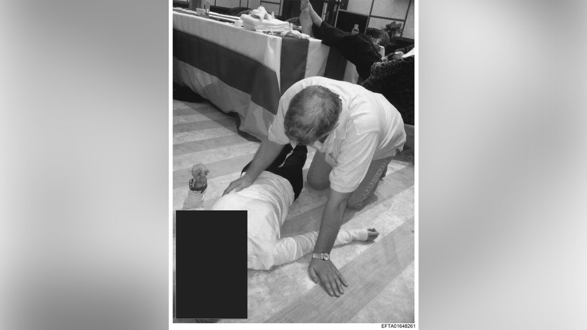 Una fotografía en blanco y negro de Andrew arrodillado junto a una mujer no identificada.