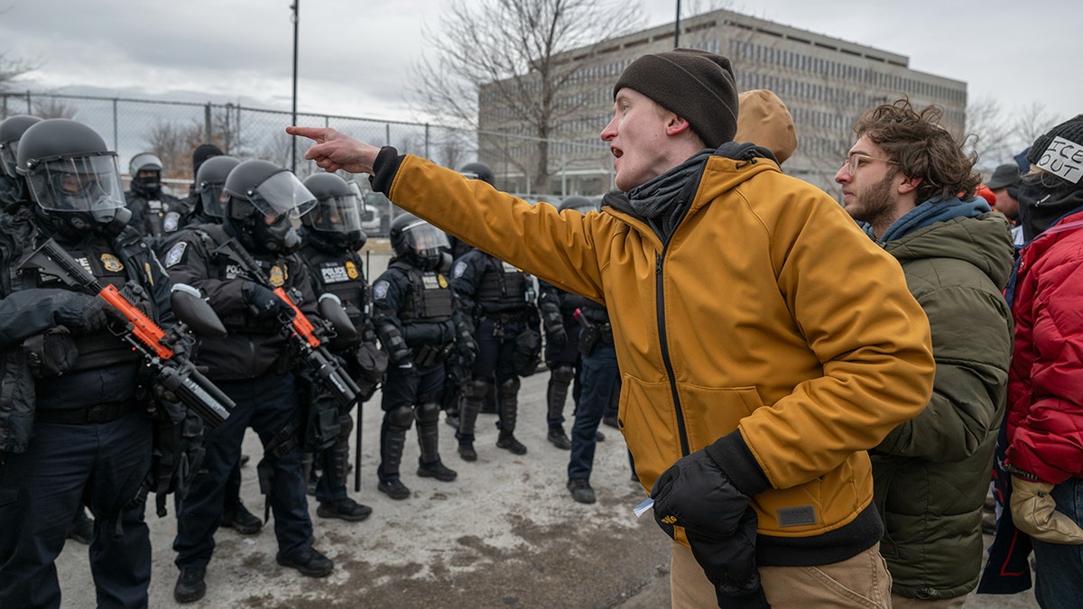 Um manifestante levanta um dedo durante um protesto anti-ICE em Minnesota