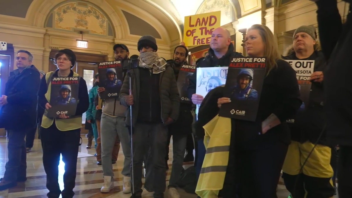 I manifestanti anti-ICE tengono cartelli.