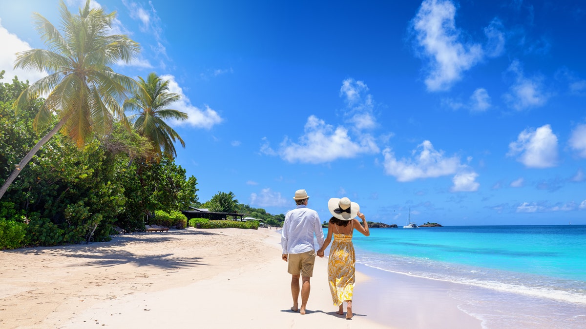 couple walking on antigua beach