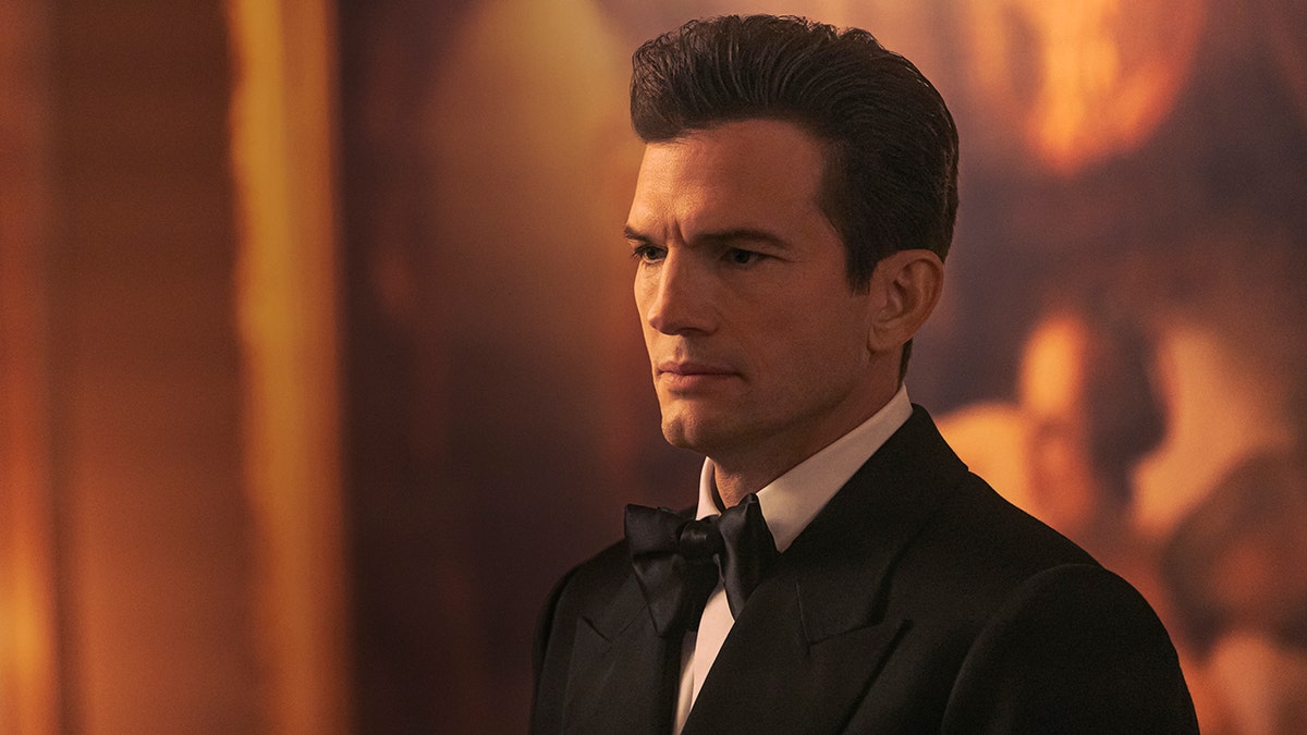 Ashton Kutcher in a black tuxedo and bow tie.