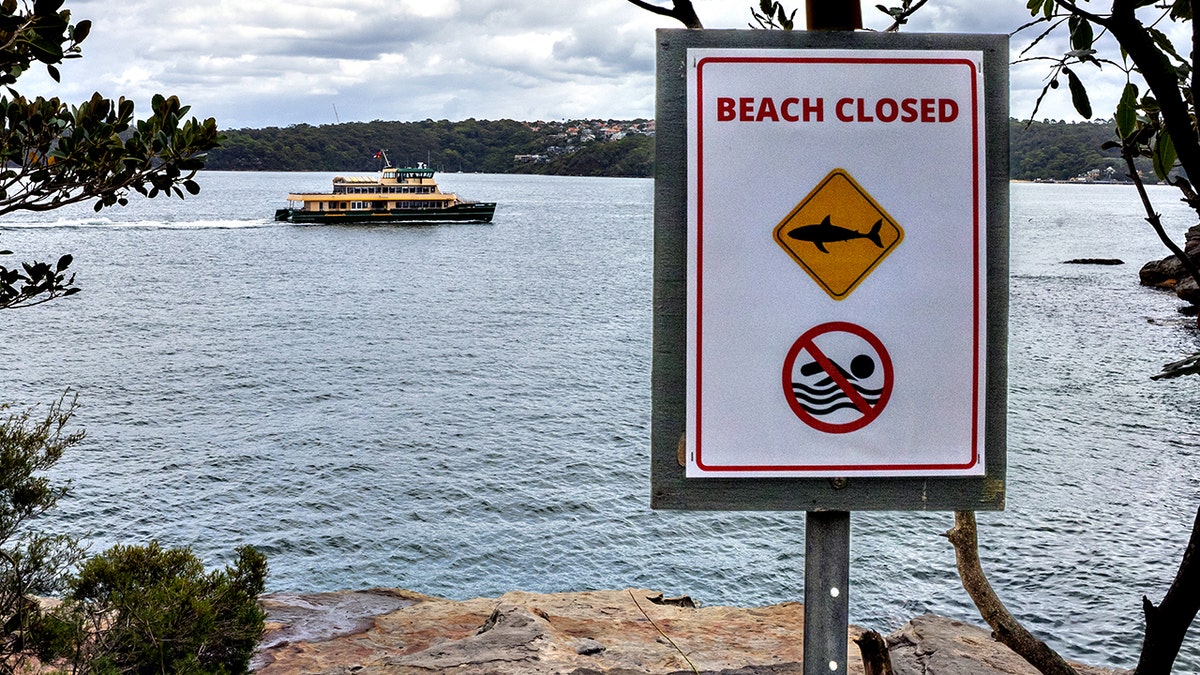 ferry sails past a closed beach