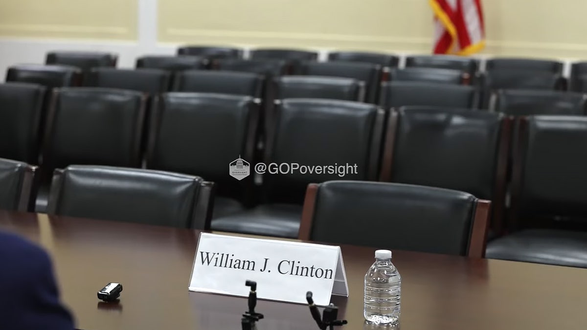 An empty chair with "William J. Clinton" on a name card in front