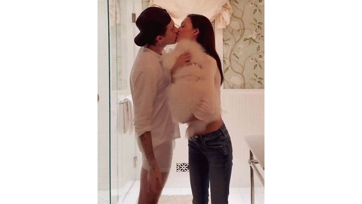 Brooklyn Beckham and Nicola Peltz sharing a kiss.