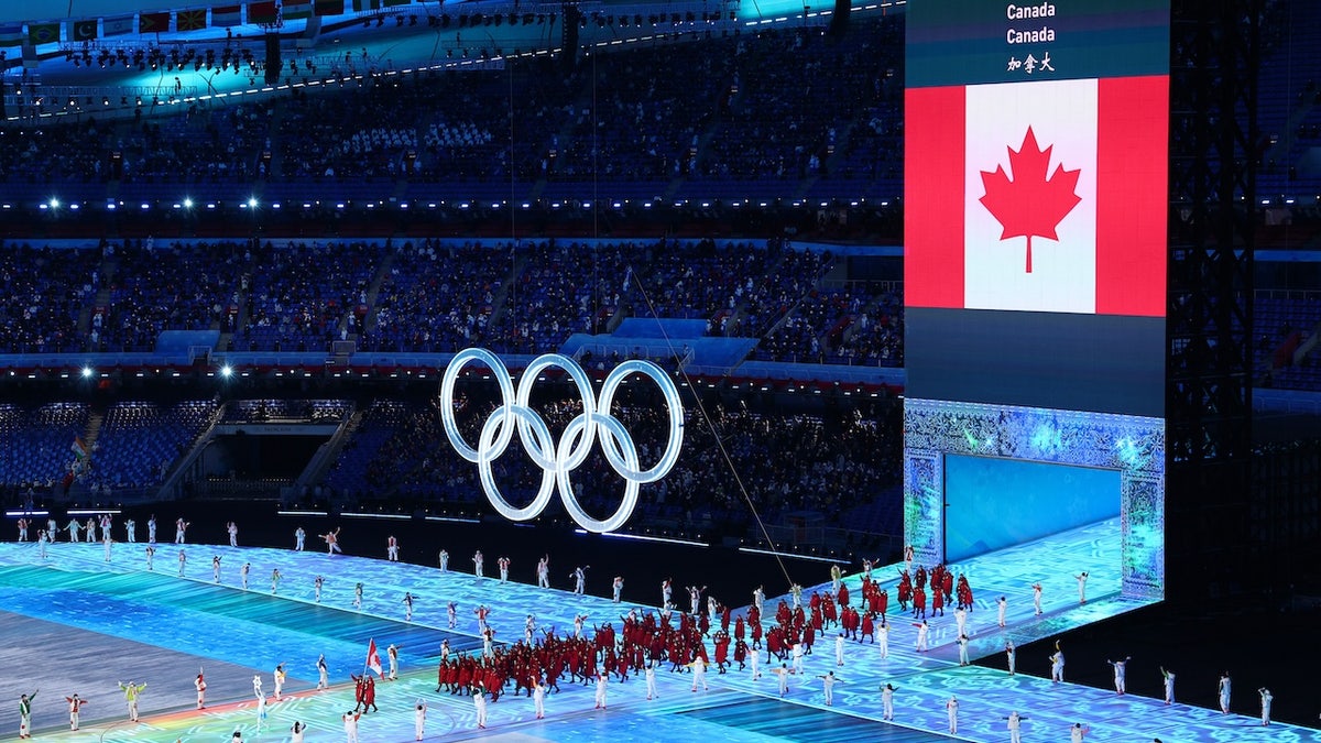 Flag bearers Charles Hamelin and Marie-Philip Poulin carry Team Canada's flag at Beijing National Stadium