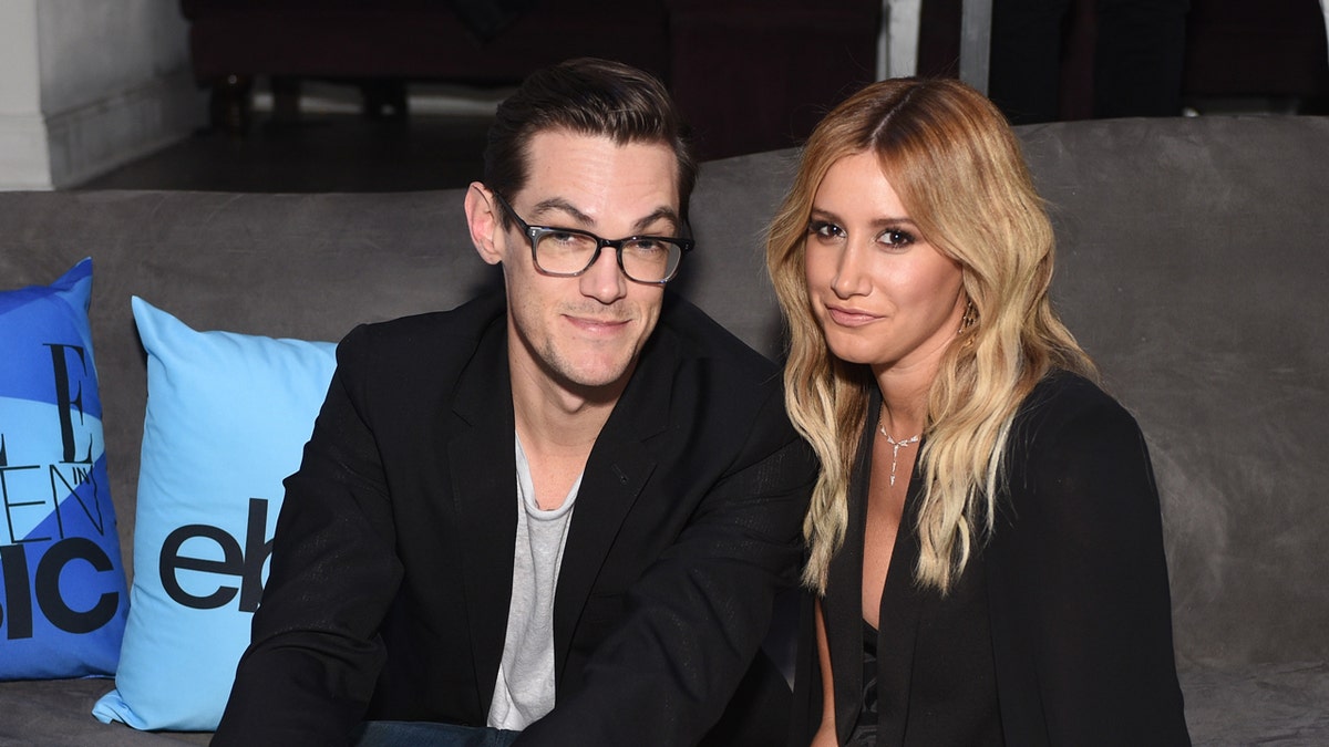 Christopher French and Ashley Tisdale sit on a couch together