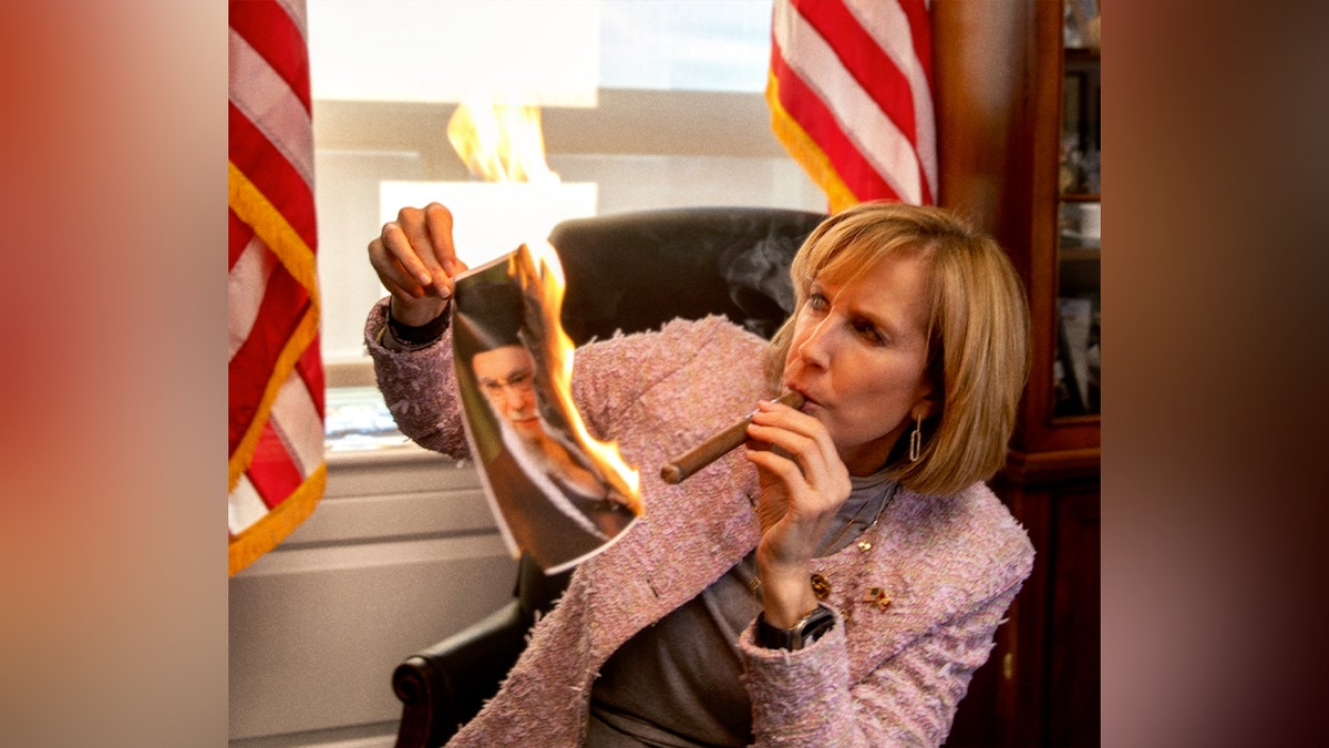 Rep. Claudia Tenney, R-N.Y., lights a cigar on a burning photo of Khamenei
