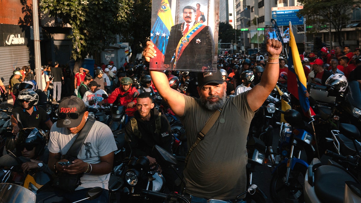 Paramilitary members rally in streets, hold poster of maduro