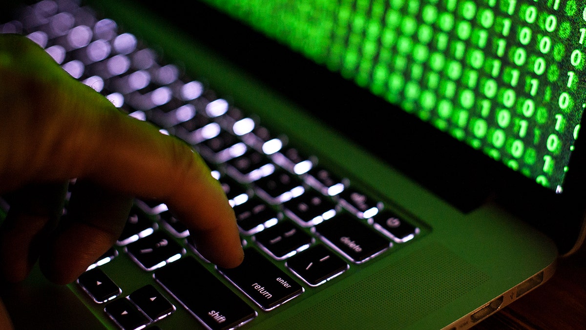 Un hacker digita il codice sul suo laptop.