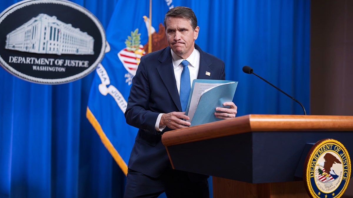 Todd Blanche speaking at a podium during a news conference at the Justice Department.