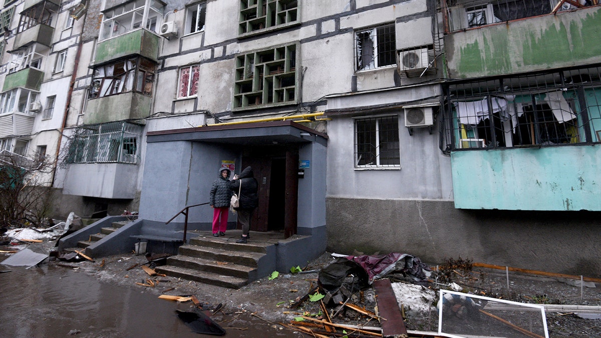 Civilians gather outside a heavily damaged apartment building after an overnight strike.