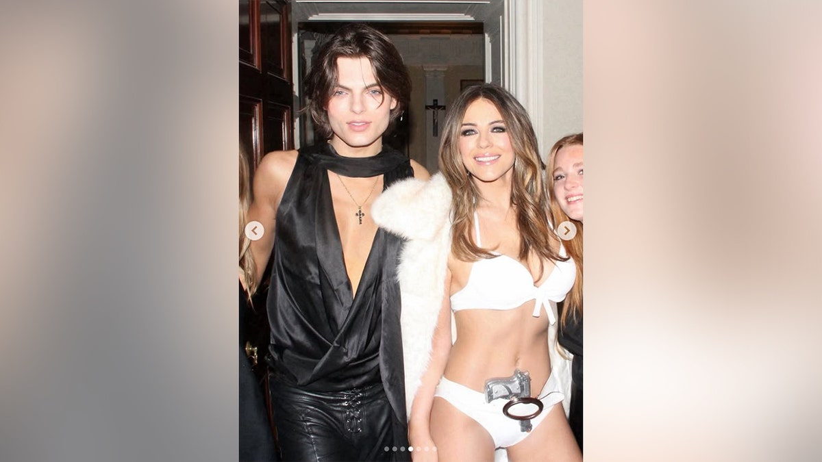 Hurley posou com seu filho que usava calça de couro e blusa decotada.