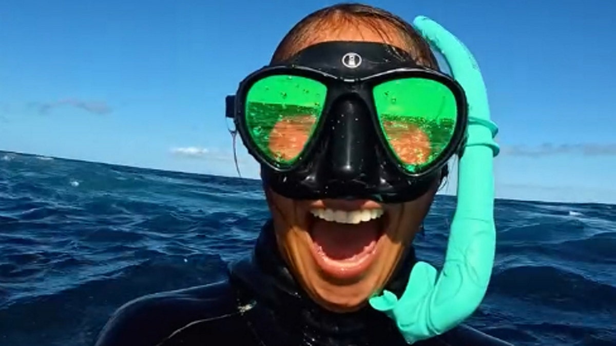 Freediver, Emily Marzilli smiling in the ocean with goggles on after seeing a brydes whale in Mexico.
