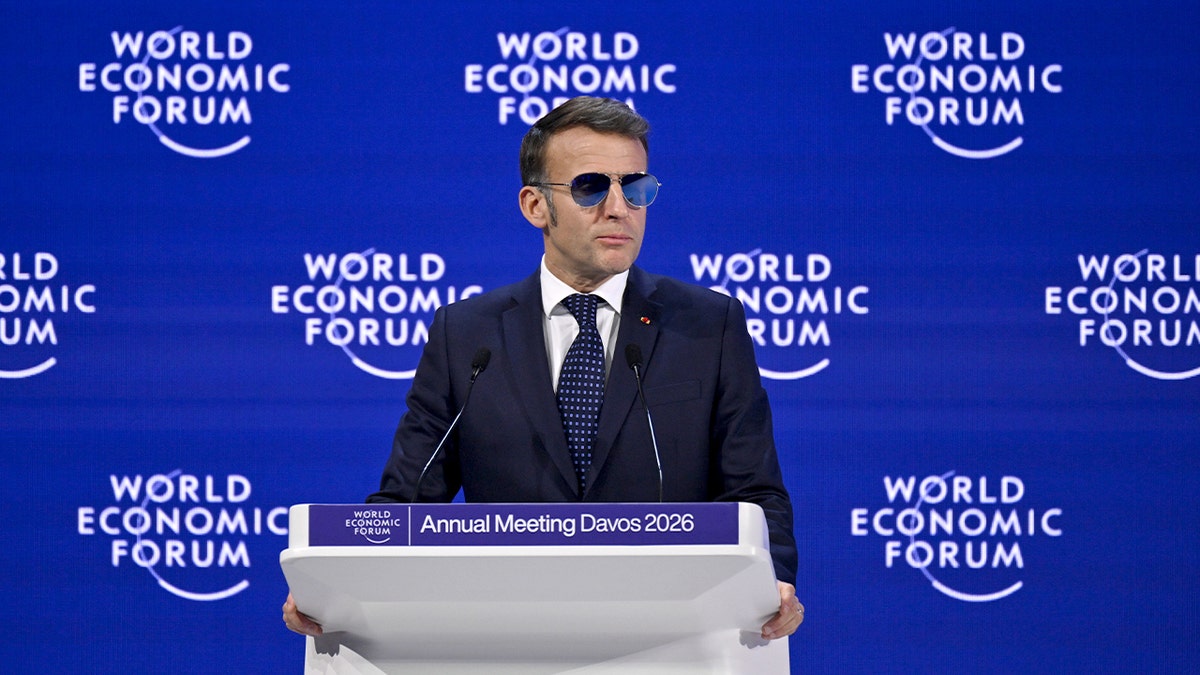 Um líder francês sobe num palco e dirige-se a uma audiência internacional numa cimeira económica global