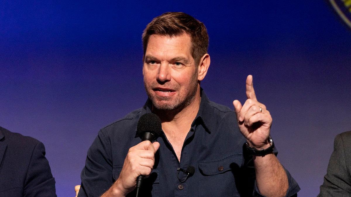 O representante Eric Swalwell fala e gesticula enquanto aponta o dedo para um microfone