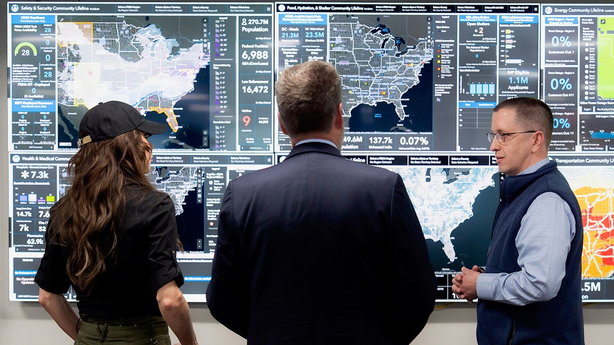Homeland Security Secretary Kristi Noem in front of information board at FEMA facility