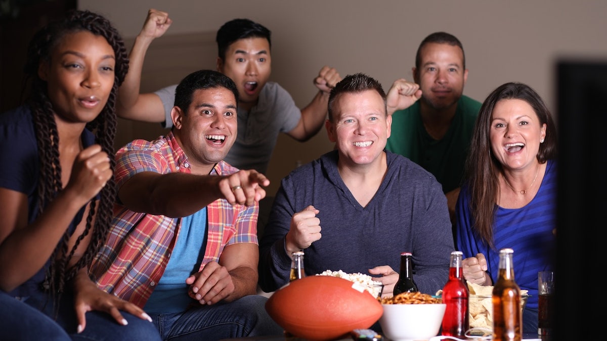 Football fans watching the game at home on television.