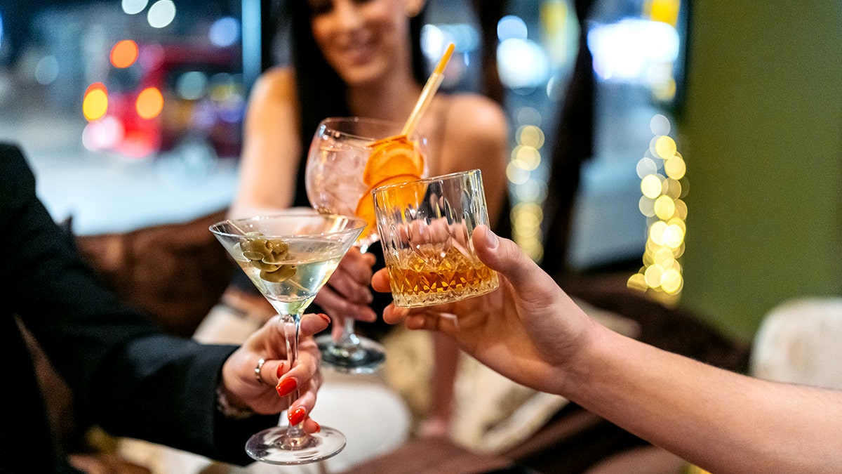 Tres amigos brindan con sus cócteles.