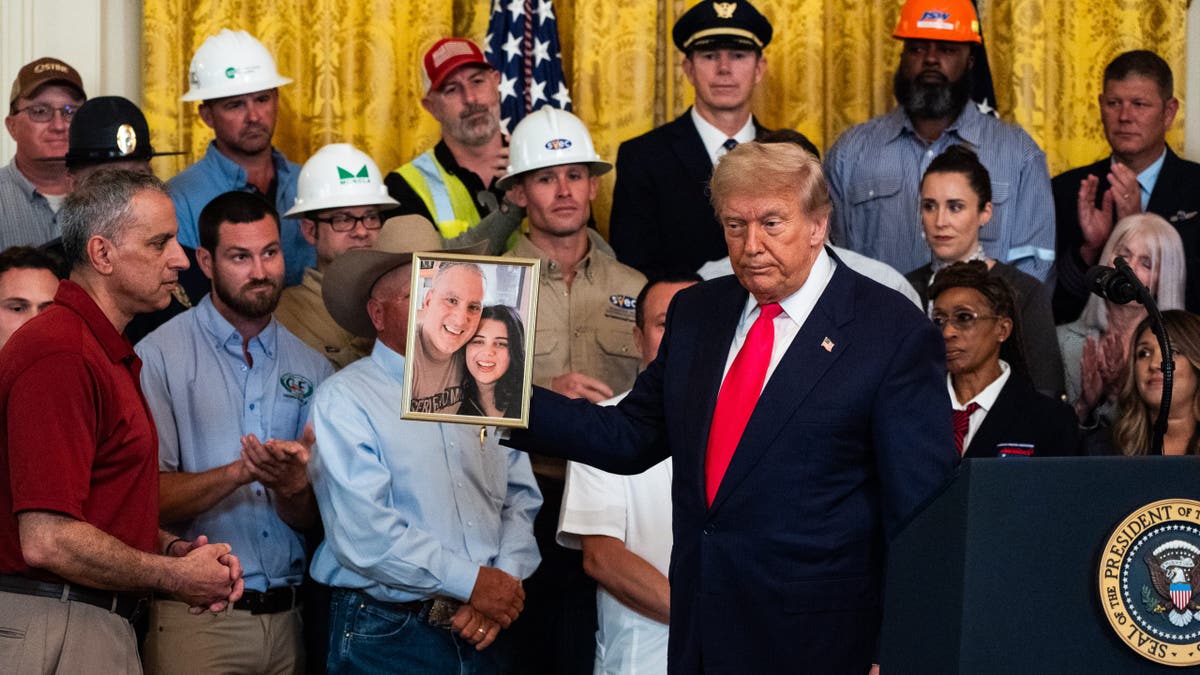 Trump holds up a photo of Katie Abraham
