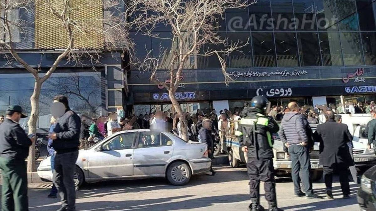 Iranian security forces stand near a crowd during demonstrations in Iran.