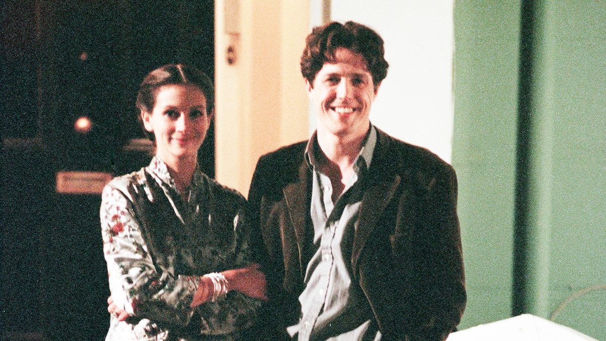 Julia Roberts and Hugh Grant stand together on the set of Notting Hill while filming in London, 1998.