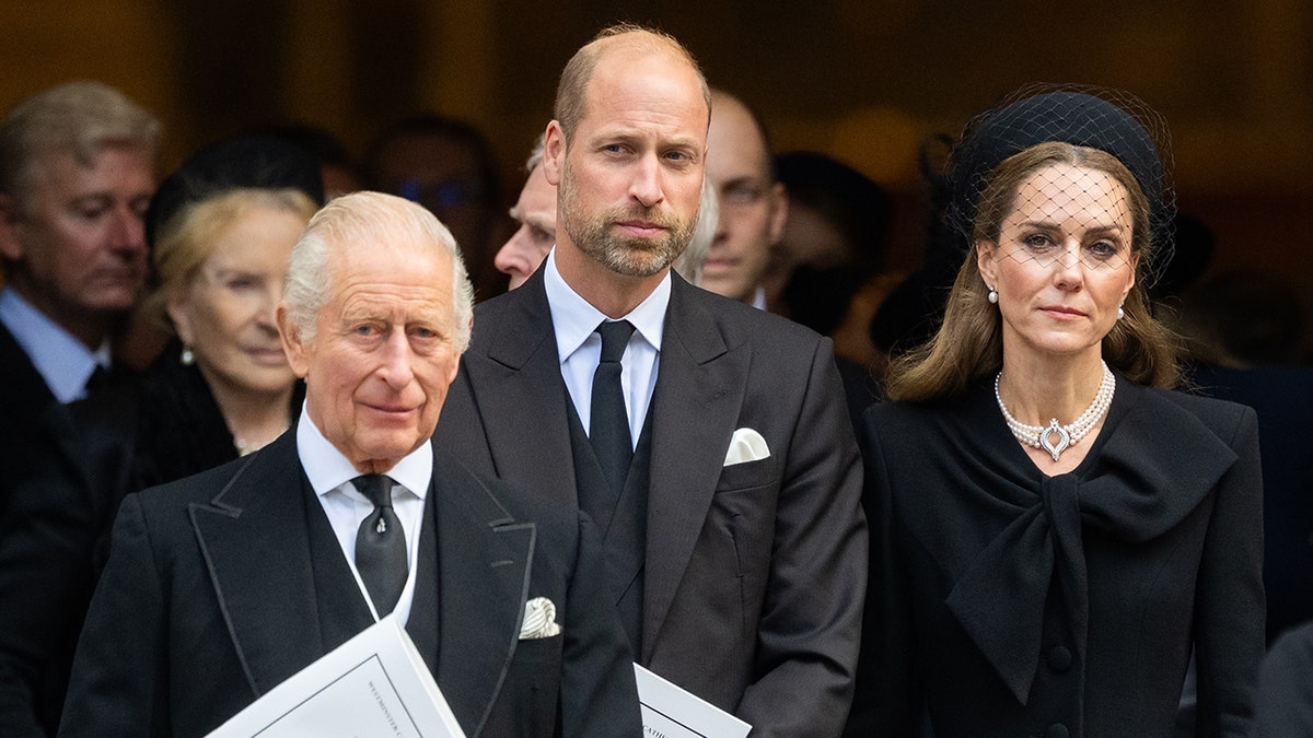 King Charles, Prince William and Kate Middleton standing together outside a church wearing black.
