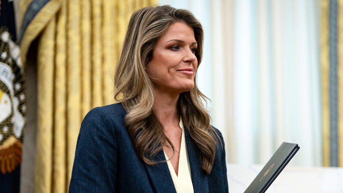 An attorney standing in the Oval Office holding documents intended for presidential signature.