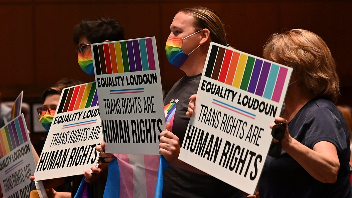Supporters of Policy 8040 holding signs celebrating at Loudoun County Public Schools Administration Building