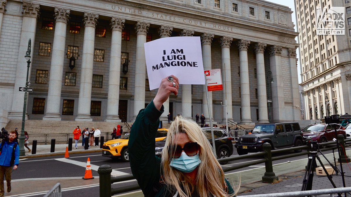 O apoiador de Luigi Mangione segura uma placa