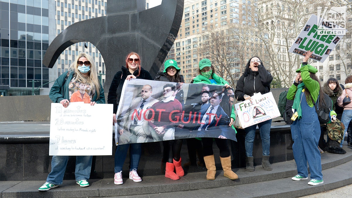 Luigi Mangione supporters hold signs