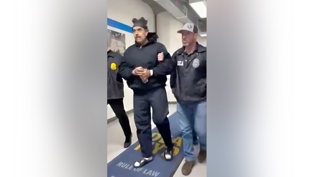 Venezuelan dictator Nicolas Maduro is led through the hallway of the DEA office in handcuffs