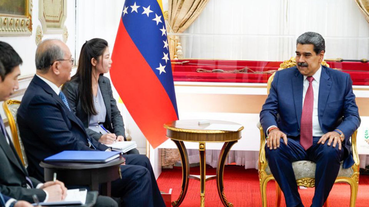 Venezuelan President Nicolas Maduro sits on chair during meeting with Chinese officials
