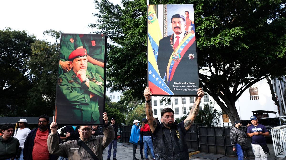Protesters in Caracas hold large posters of Nicolás Maduro and Hugo Chávez during a rally.