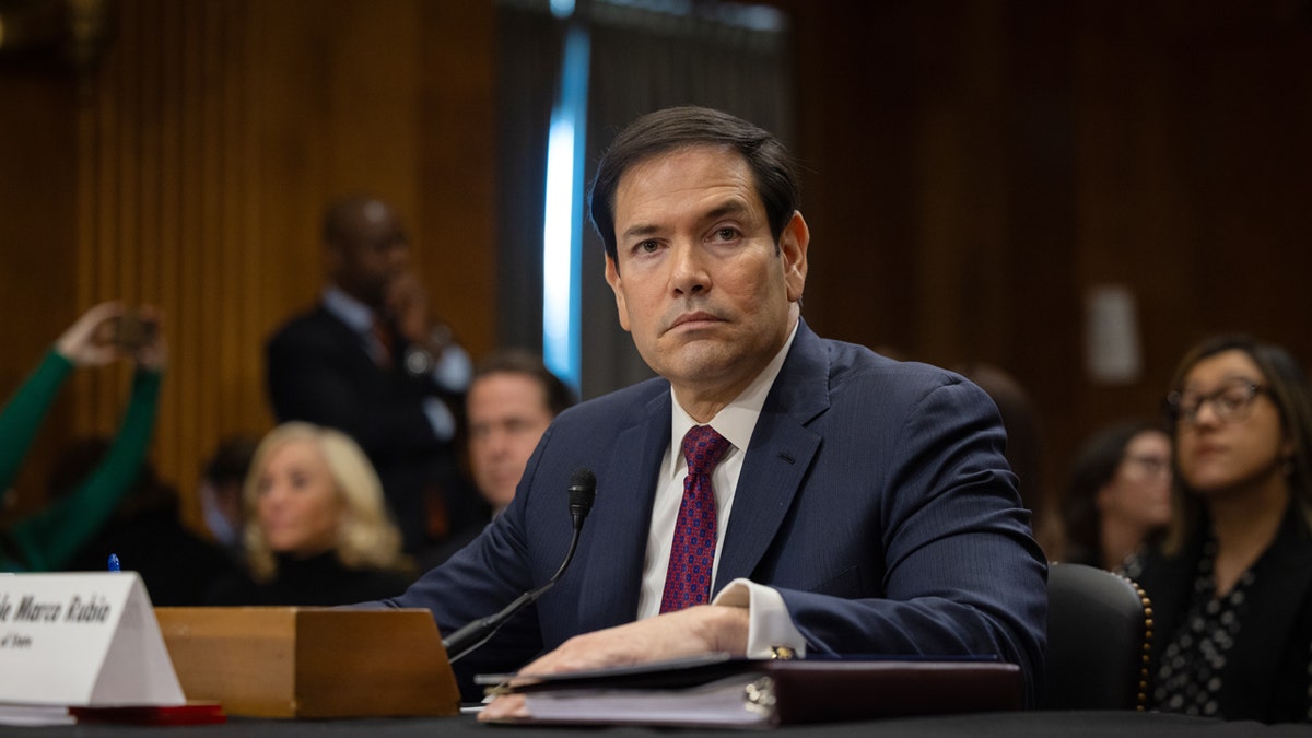 Marco Rubio looking into the distance while sitting at a desk
