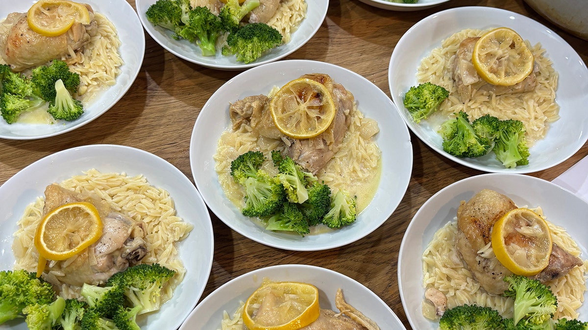 7 plates of chicken francese prepped in Mary Neilis' kitchen, with side of broccoli and topped with lemons.