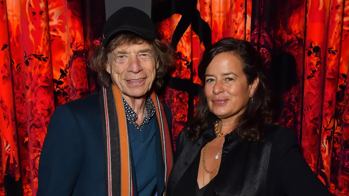Sir Mick Jagger and Jade Jagger standing together at a cocktail reception.