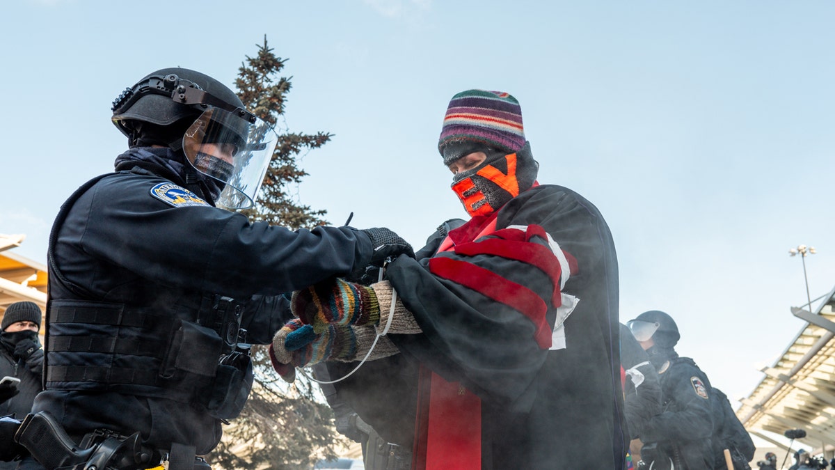 ICE siendo esposado por la policía.