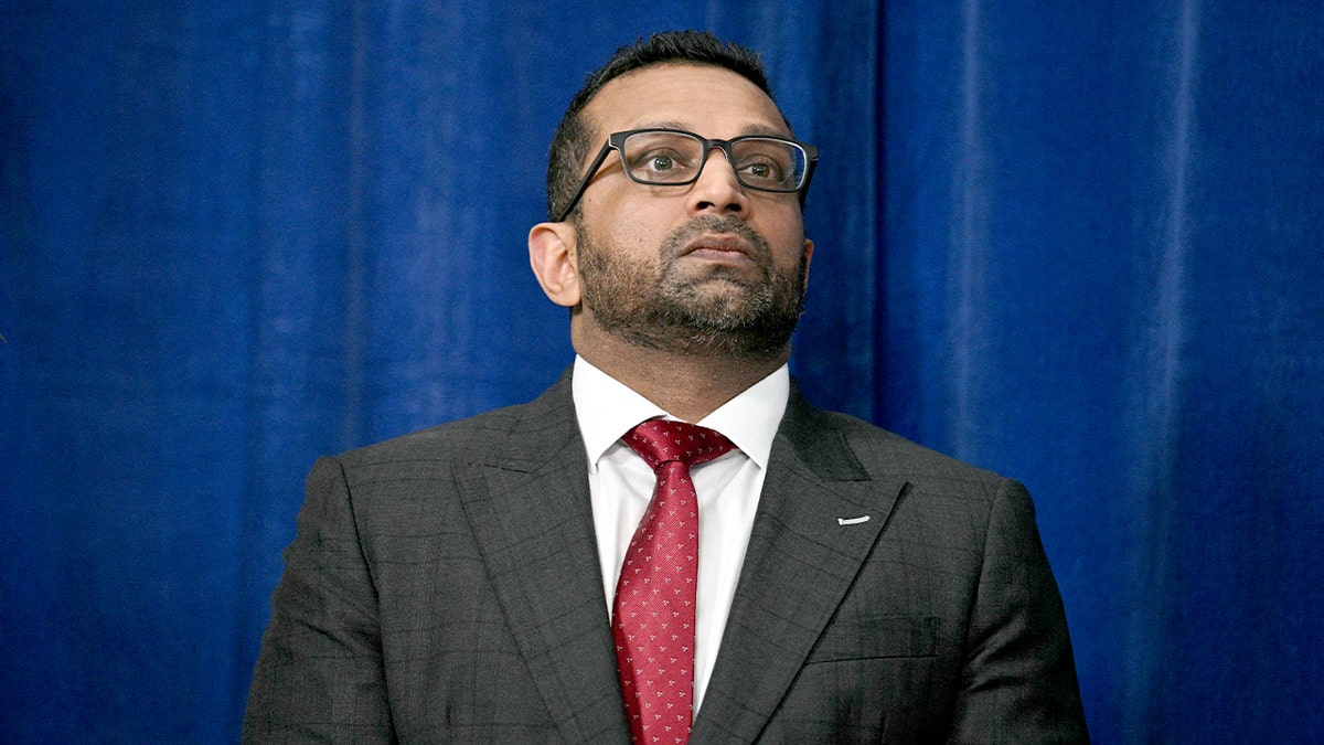 The FBI director stands nearby as the U.S. president addresses reporters at a resort following military action abroad.