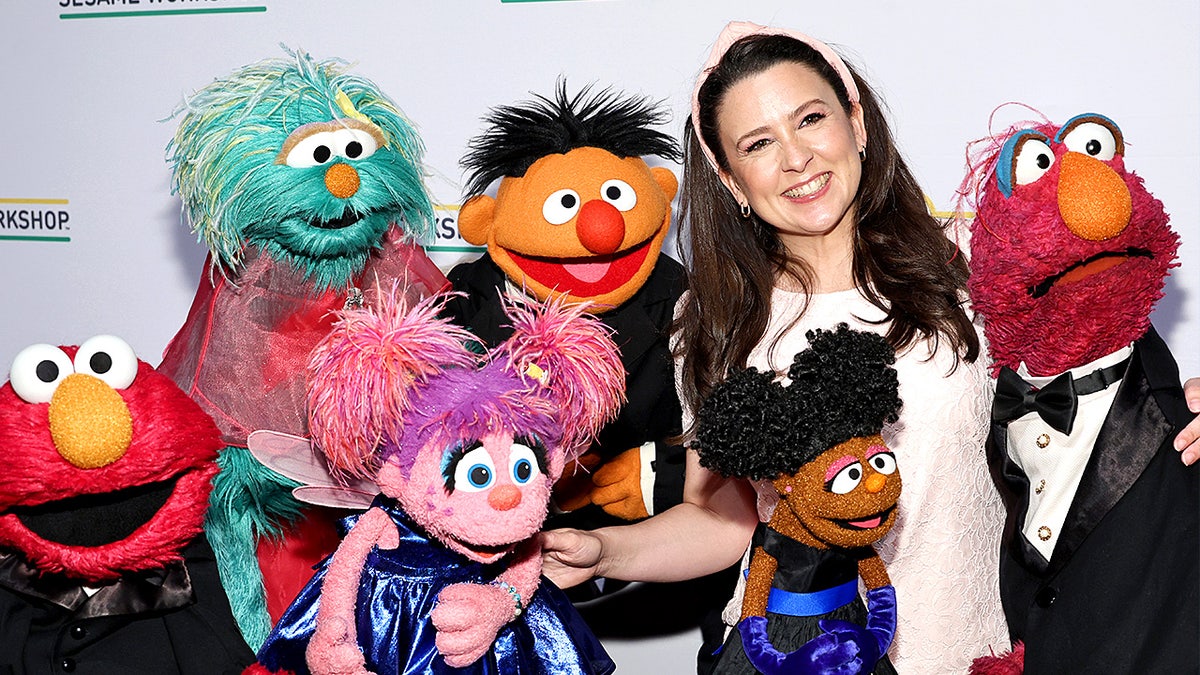 Ms. Rachel poses for photographs while standing at a formal event.