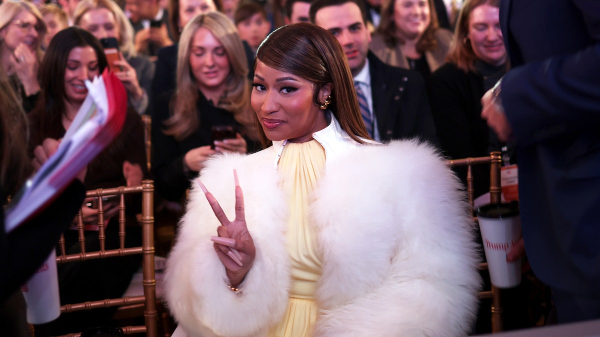 Nicki Minaj attends the Trump Accounts Summit while seated in the Andrew W. Mellon Auditorium.