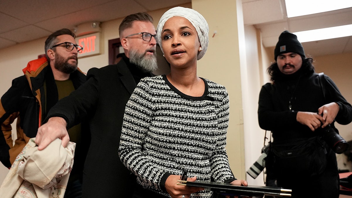 Rep. Ilhan Omar clutches a binder at a town hall