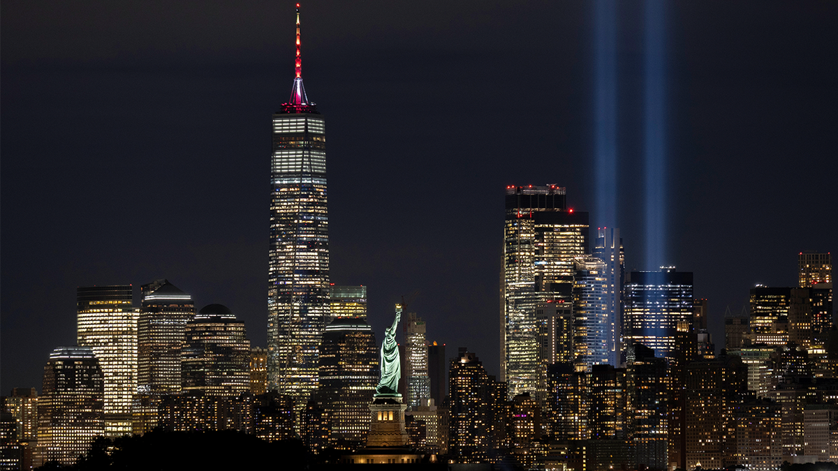 The Tribute in Light is illuminated above the skyline of lower Manhattan and One World Trade Center behind the Statue of Liberty ahead of the 24th anniversary of the 9/11 attacks in New York City on September 10, 2025, as seen from Jersey City, New Jersey.
