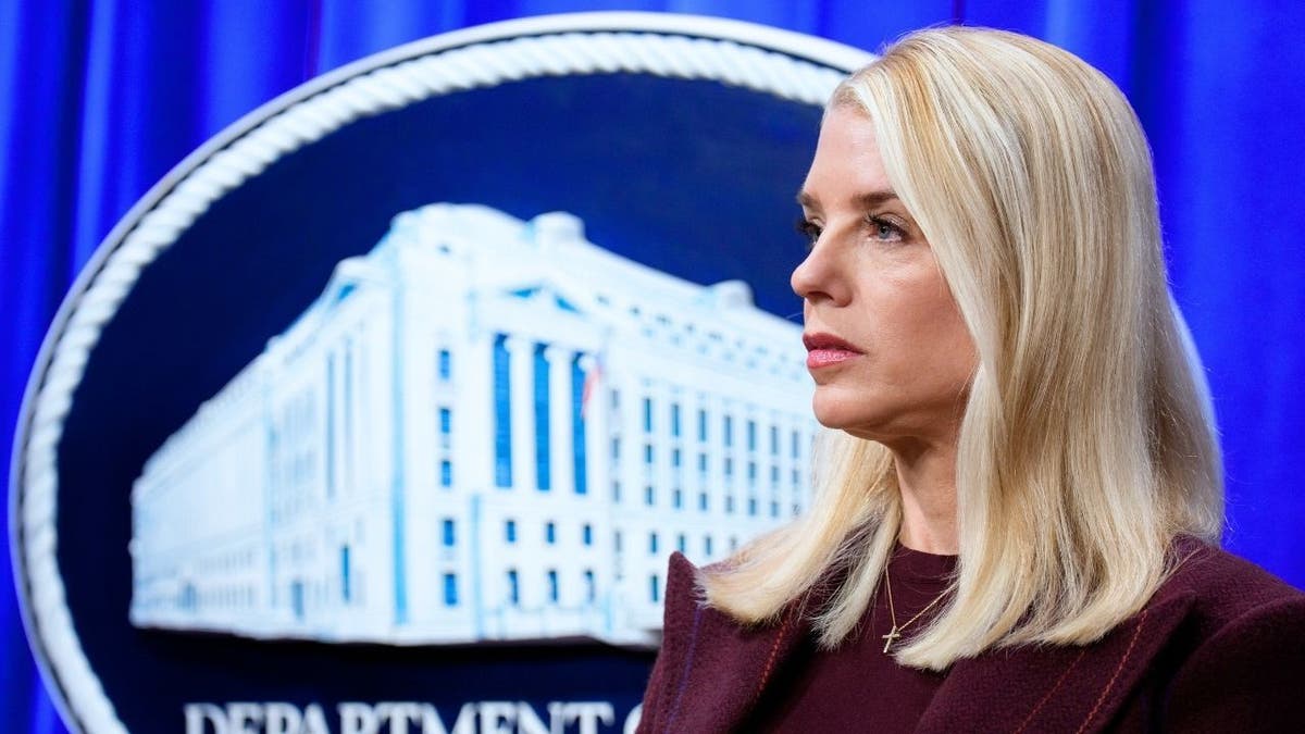 Pam Bondi in front of DOJ symbol