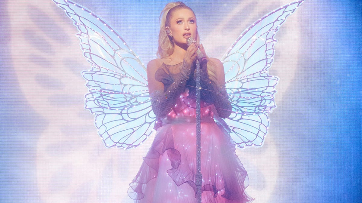 Paris Hilton dressed as a fairy performing on stage.