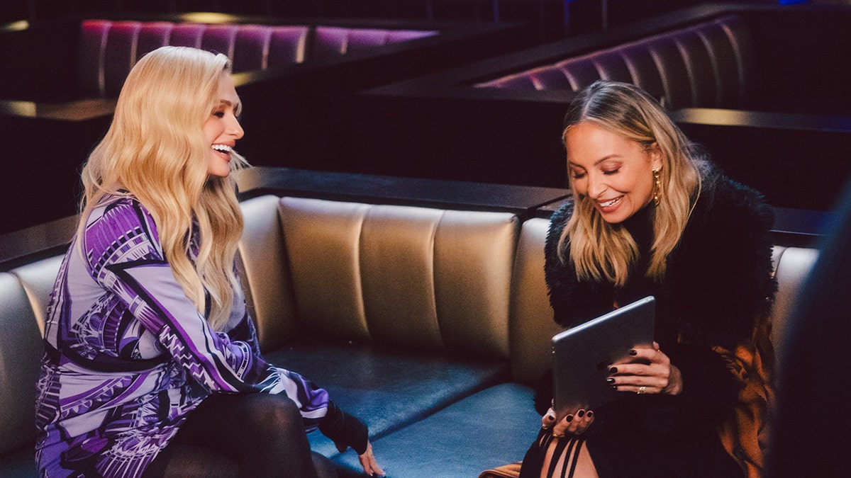 Paris Hilton and Nicole Richie laughing together at a studio.