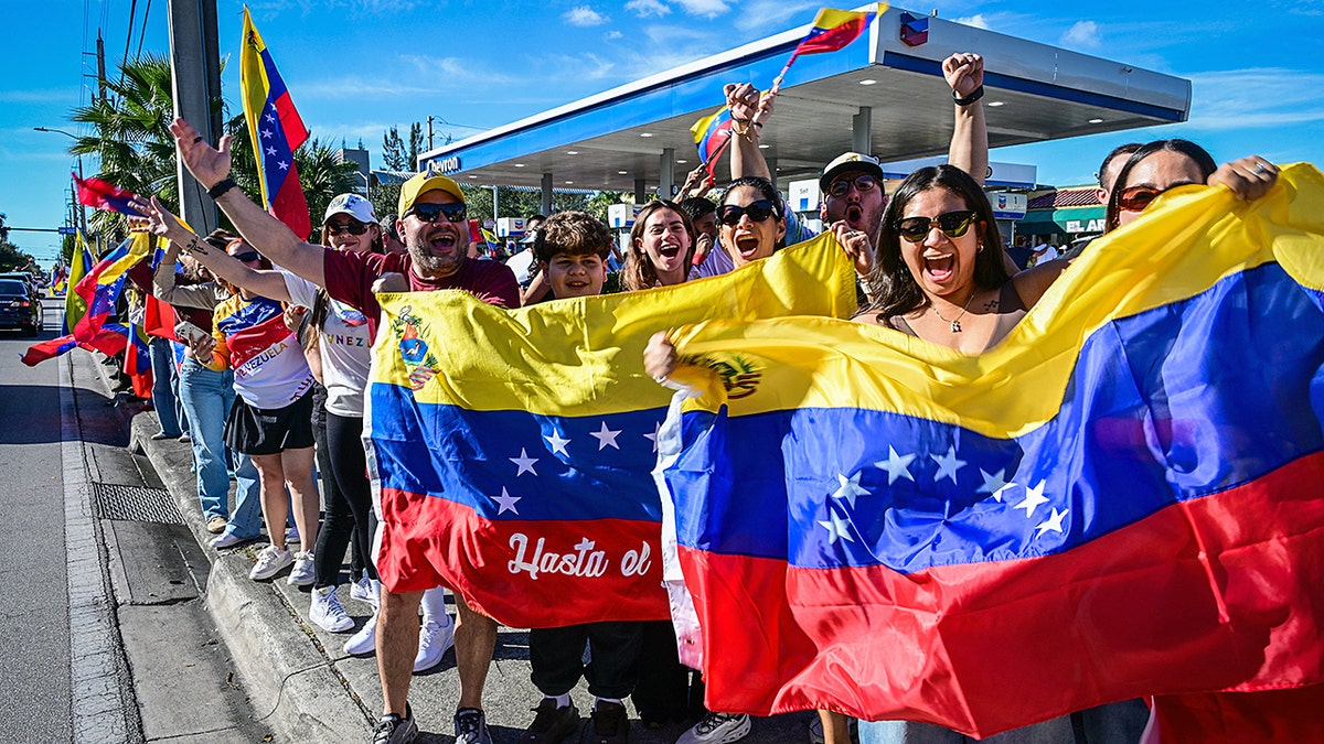 People hold Venezuelan flags in celebration
