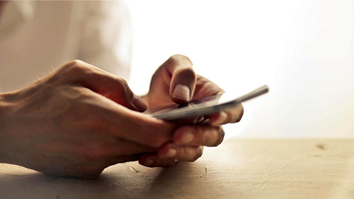 La personne tient un téléphone