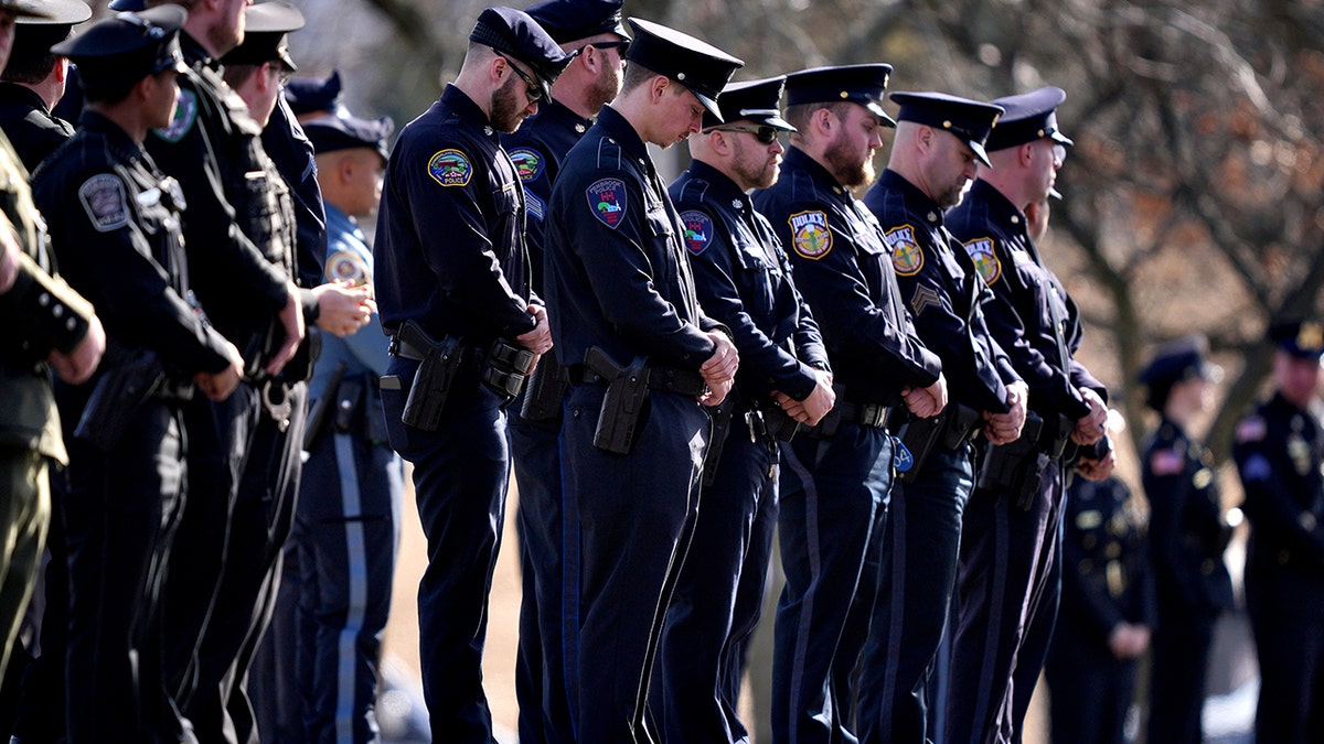 Officers wait for funeral procession